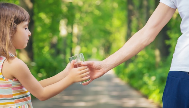 Père donnant à l'enfant un verre d'eau