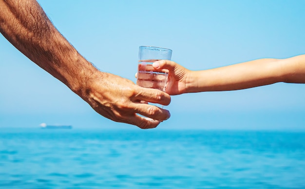 Le père donne à l'enfant un verre d'eau. Mise au point sélective.