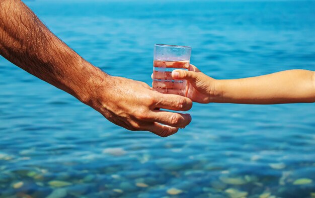 Le père donne à l'enfant un verre d'eau. Mise au point sélective.