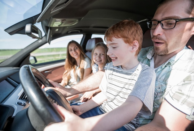 Père drôle et son petit fils conduisant une voiture