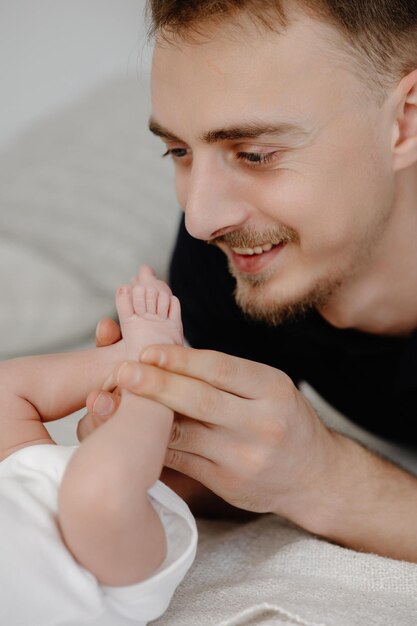 Père embrasse la jambe du bébé Amour pour l'enfant