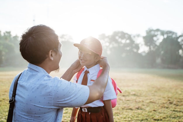 Père emmenant sa fille à l'école primaire le matin