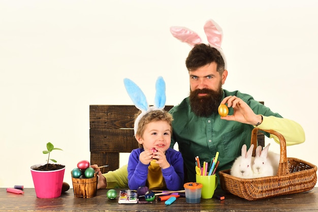 Père et enfant peignant des oeufs de pâques oeuf de pâques décorant une famille heureuse