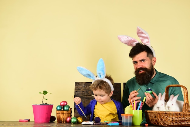 Père et enfant peignant des oeufs de pâques oeuf de pâques décorant une famille heureuse