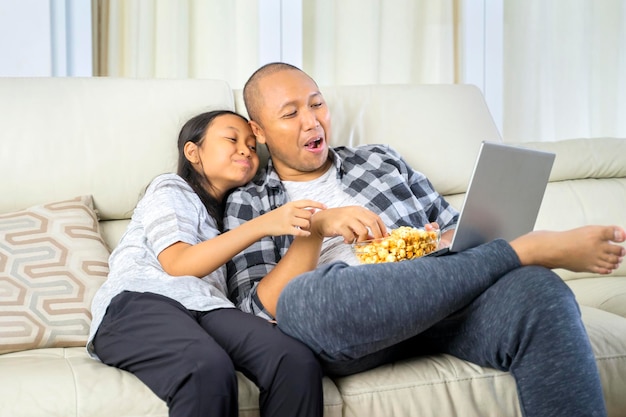 Père et enfant regardant un film sur un ordinateur portable