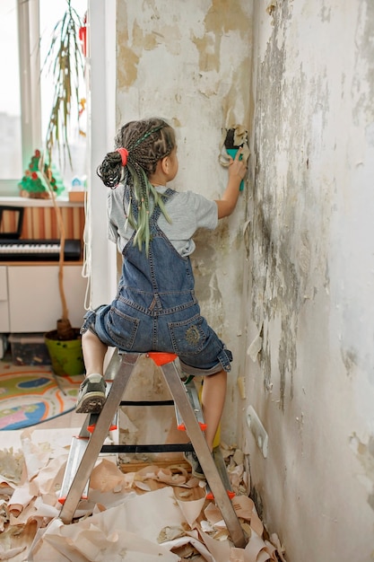 Père avec enfant réparant la pièce ensemble et papier peint immuable ensemble