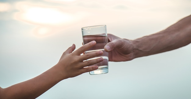 Père et enfant avec un verre d'eau. Mise au point sélective.