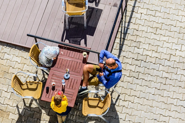 Père avec enfants dans un café de rue confortable. Vue de dessus