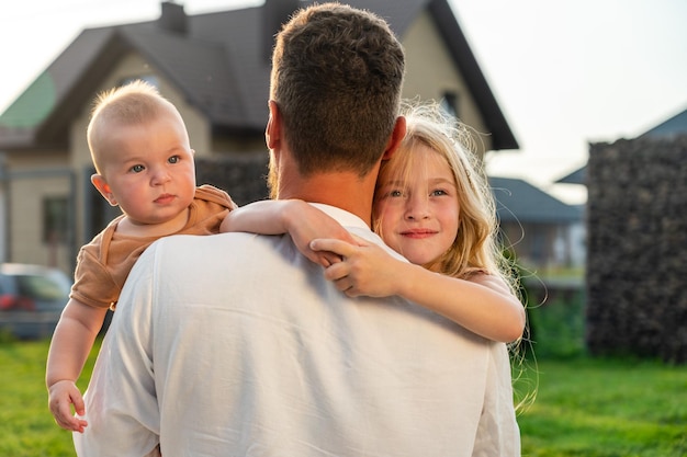 Père avec des enfants heureux et souriants en été