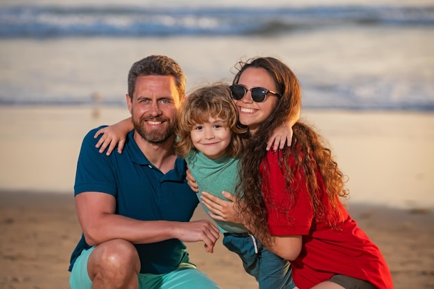 Père et enfants jouant sur la plage concept de famille amicale famille étreignant en plein air