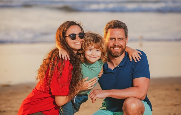 Père et enfants jouant sur la plage concept de famille amicale famille étreignant en plein air