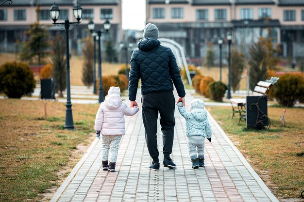 père avec enfants marchant dans le parc