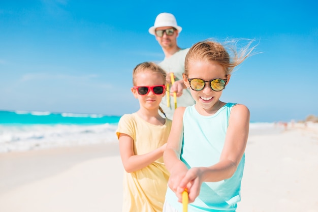 Père et enfants profitant des vacances d'été à la plage