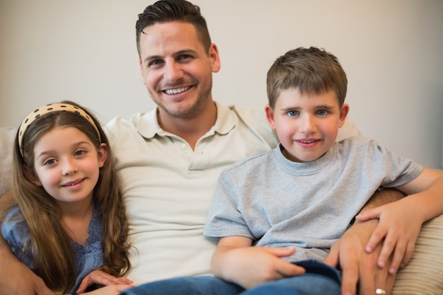 Père et enfants, souriant sur le canapé