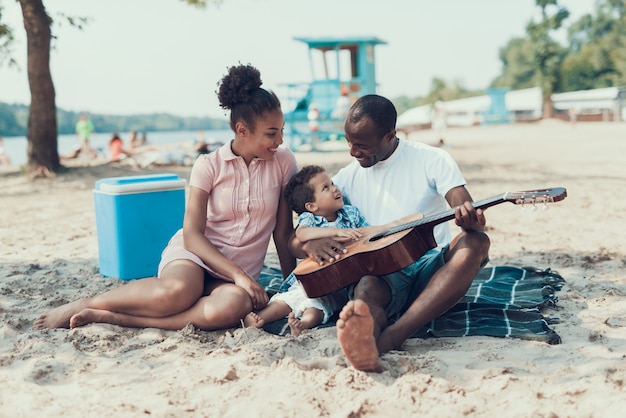 Père enseignant fils joue à la guitare