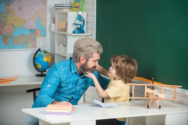 Père enseignant à son fils aidant les élèves à l'éducation scolaire fond tutorat à l'école primaire plaisir...