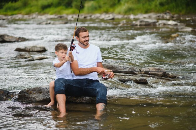 Père enseignant à son fils comment pêcher dans la rivière