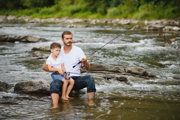 Père enseignant à son fils comment pêcher dans la rivière