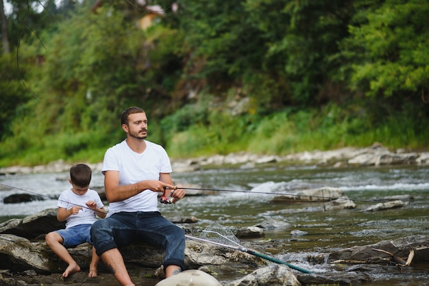 Père enseignant à son fils comment pêcher dans la rivière