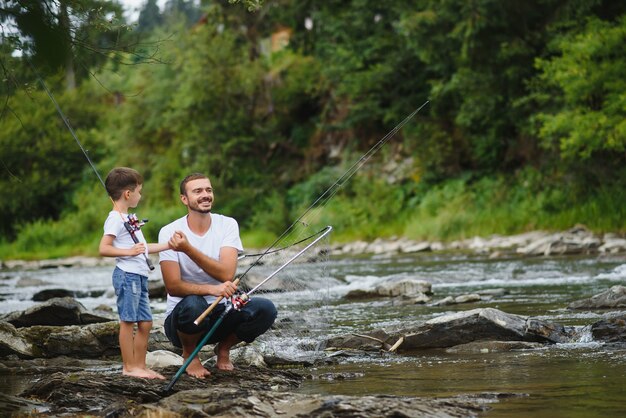 Père enseignant à son fils comment pêcher dans la rivière