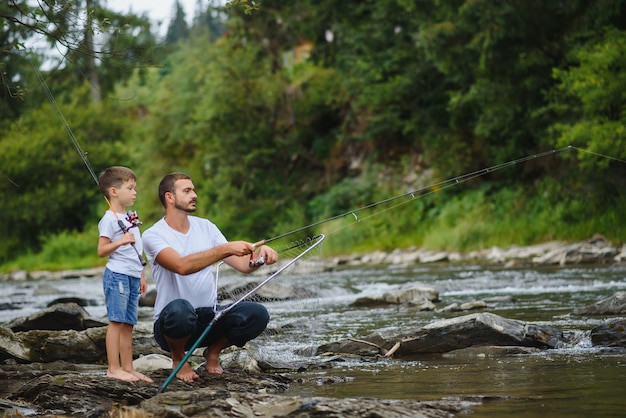 Père enseignant à son fils comment pêcher dans la rivière