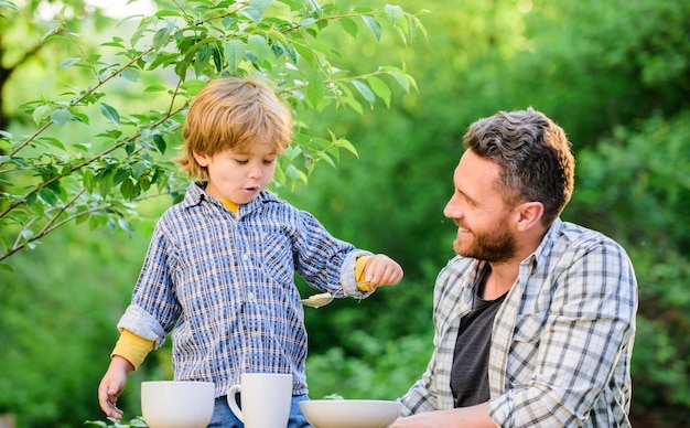 Père enseigne à son fils à manger des aliments naturels Petit garçon et papa mangent Nutrition biologique Concept de nutrition saine Habitudes nutritionnelles La famille profite d'un repas fait maison Exemple personnel Nutrition enfants et adultes