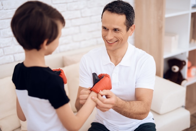 Le père entraîne son fils à la boxe.