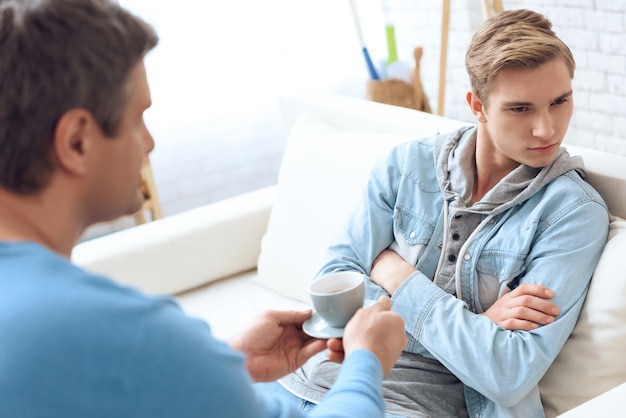 Père essaie de parler à son fils lui apporte du café.