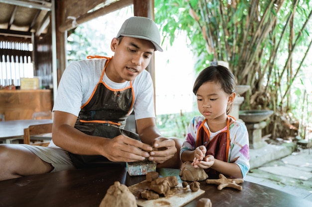 Père et fille asiatique travaillant avec de l'argile
