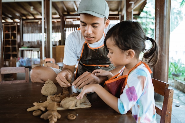 Père et fille asiatique travaillant avec de l'argile