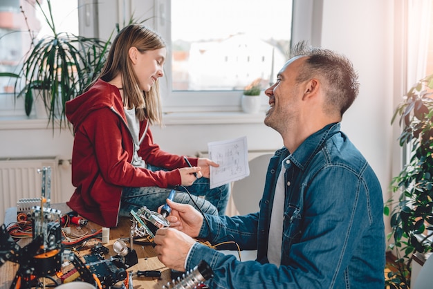 Père et fille construisant un robot et s'amusant