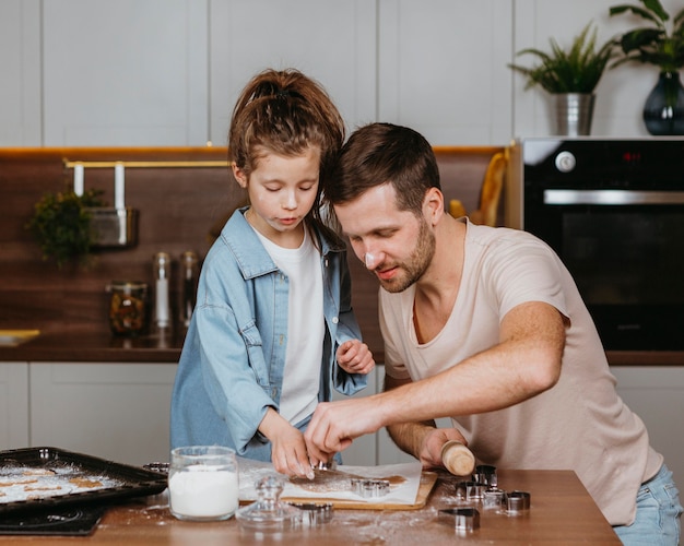 Photo père et fille cuisiner ensemble dans la cuisine