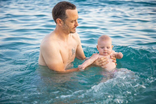 Photo père et fille dans la mer contre le ciel