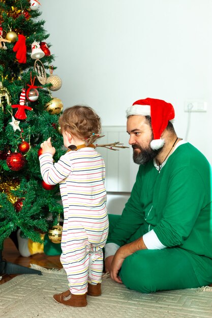 Père et fille décorent le sapin de Noël