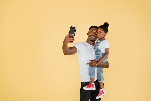 Père et fille d'une famille afro-américaine s'amusant et utilisant un appel vidéo sur téléphone portable