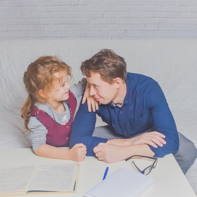 Photo le père et la fille font leurs devoirs après l'école primaire