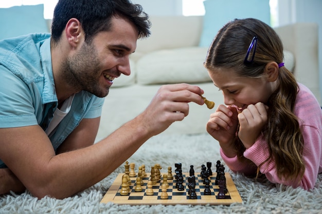 Père et fille jouant aux échecs dans le salon