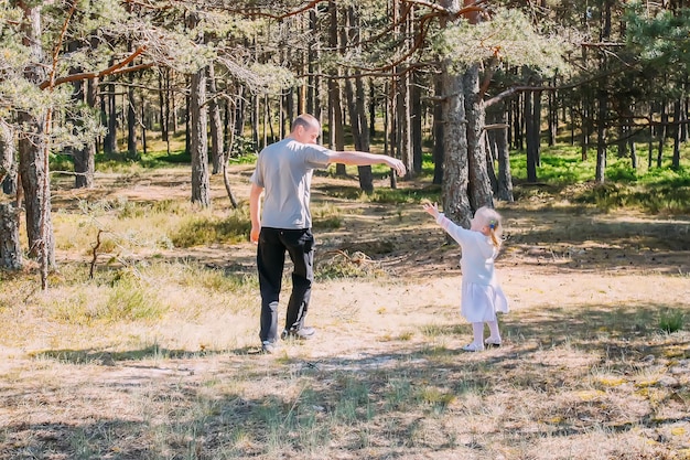 Père et fille jouant dans une forêt de printemps Les personnes actives passent un bon moment à l'extérieur