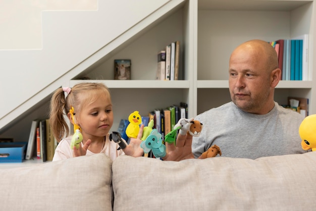 Père et fille jouant avec de jolies marionnettes