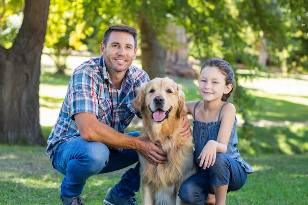 Père et fille avec leur chien dans le parc