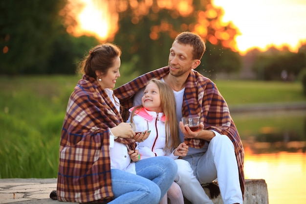 père, fille et une maman enceinte lors d'un pique-nique.