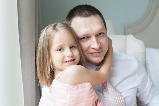 Père et fille se câlinant à la maison