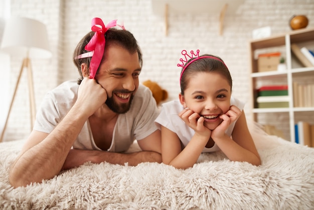 Père et fille sont couchés sur le lit.