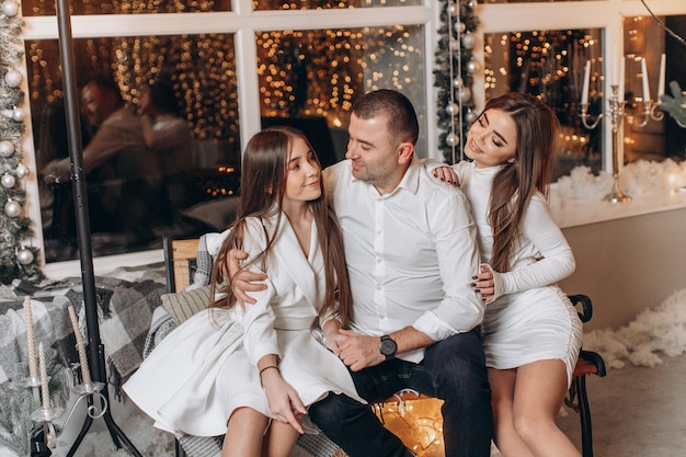 père et filles près de l'arbre de noël