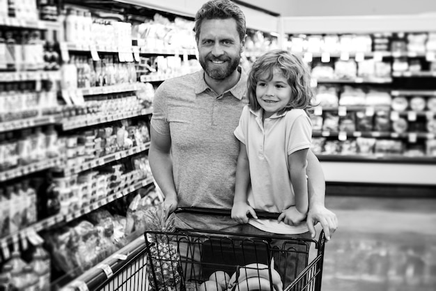 Père et fils achètent un produit dans une épicerie familiale dans un magasin