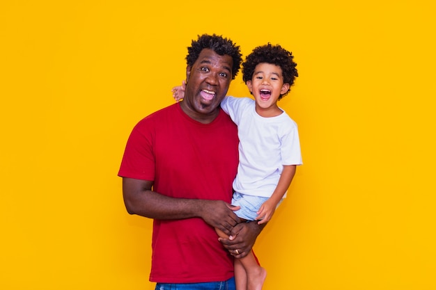 Père et fils afro sur fond jaune souriant. Concept de la fête des pères