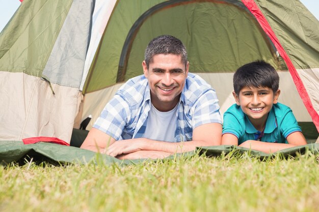 Père et fils allongé à côté de leur tente