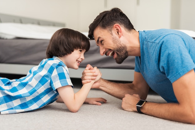 Père et fils allongés sur le sol et s&#39;amuser à la maison