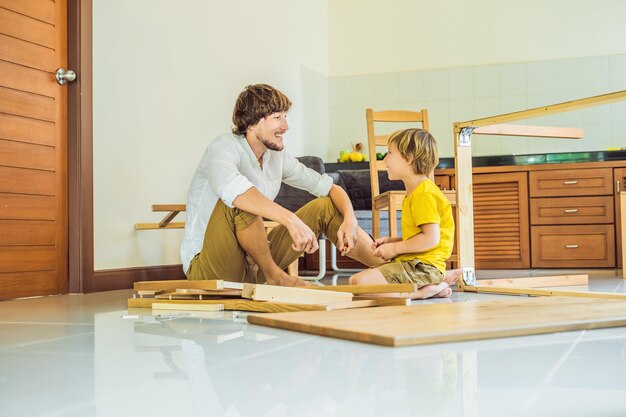 Père et fils assemblant des meubles Garçon aidant son père à la maison Concept de famille heureuse