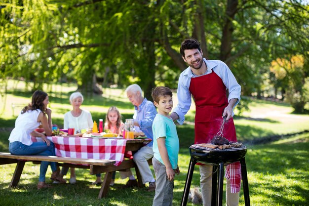 Père et fils barbecue dans le parc pendant la journée